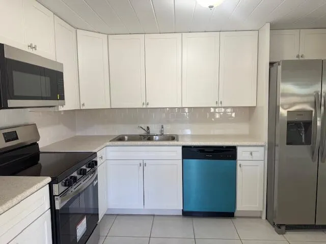 a kitchen with stainless steel appliances granite countertop a stove a refrigerator and a microwave