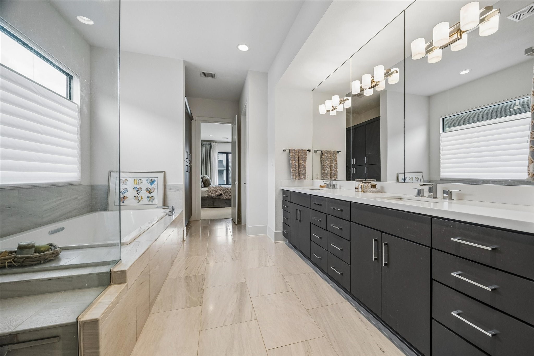 1526 Vermont Street Houston, TX 77006 - Photo 30 of 39 Spa-inspired primary bath with dual-sink vanity, soaking tub, separate glass-enclosed shower, and refined finishes.
