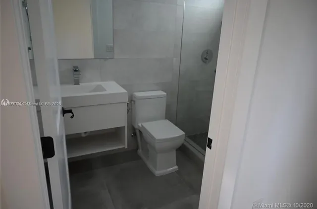 a white toilet sitting next to a bathroom sink