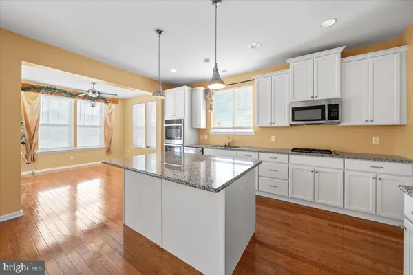 a kitchen with stainless steel appliances granite countertop a sink a stove and cabinets