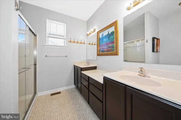 a en suite bathroom with a double vanity sink and a mirror