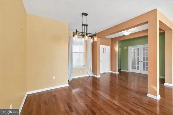 a view of a room with wooden floor a ceiling fan