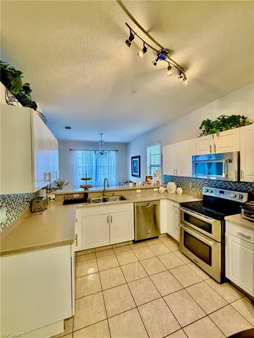 a kitchen with a sink appliances and cabinets
