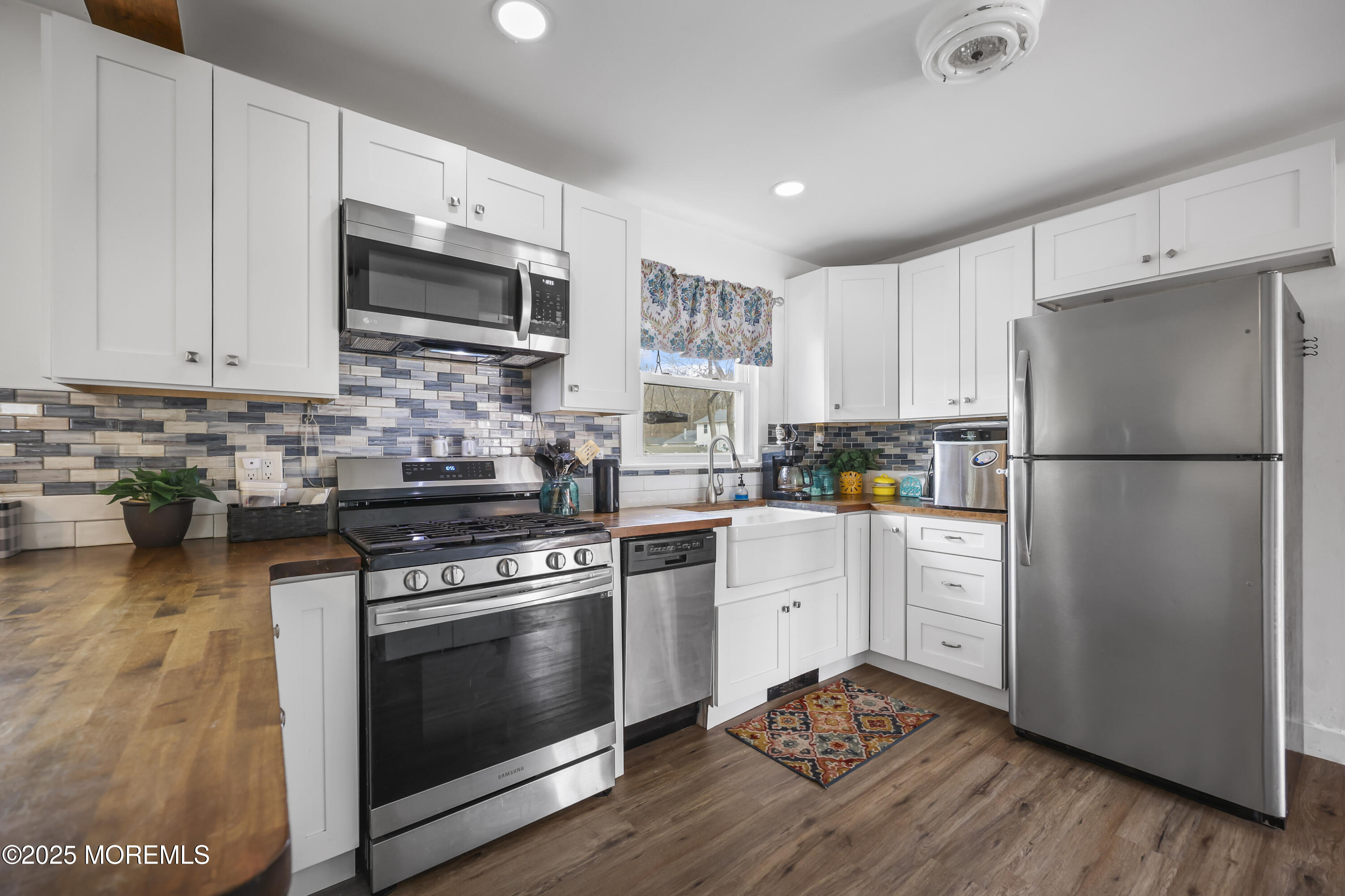 20 Ermack Street Howell, NJ 07731 - Photo 18 of 25 a kitchen with stainless steel appliances white cabinets white stove a sink and a refrigerator