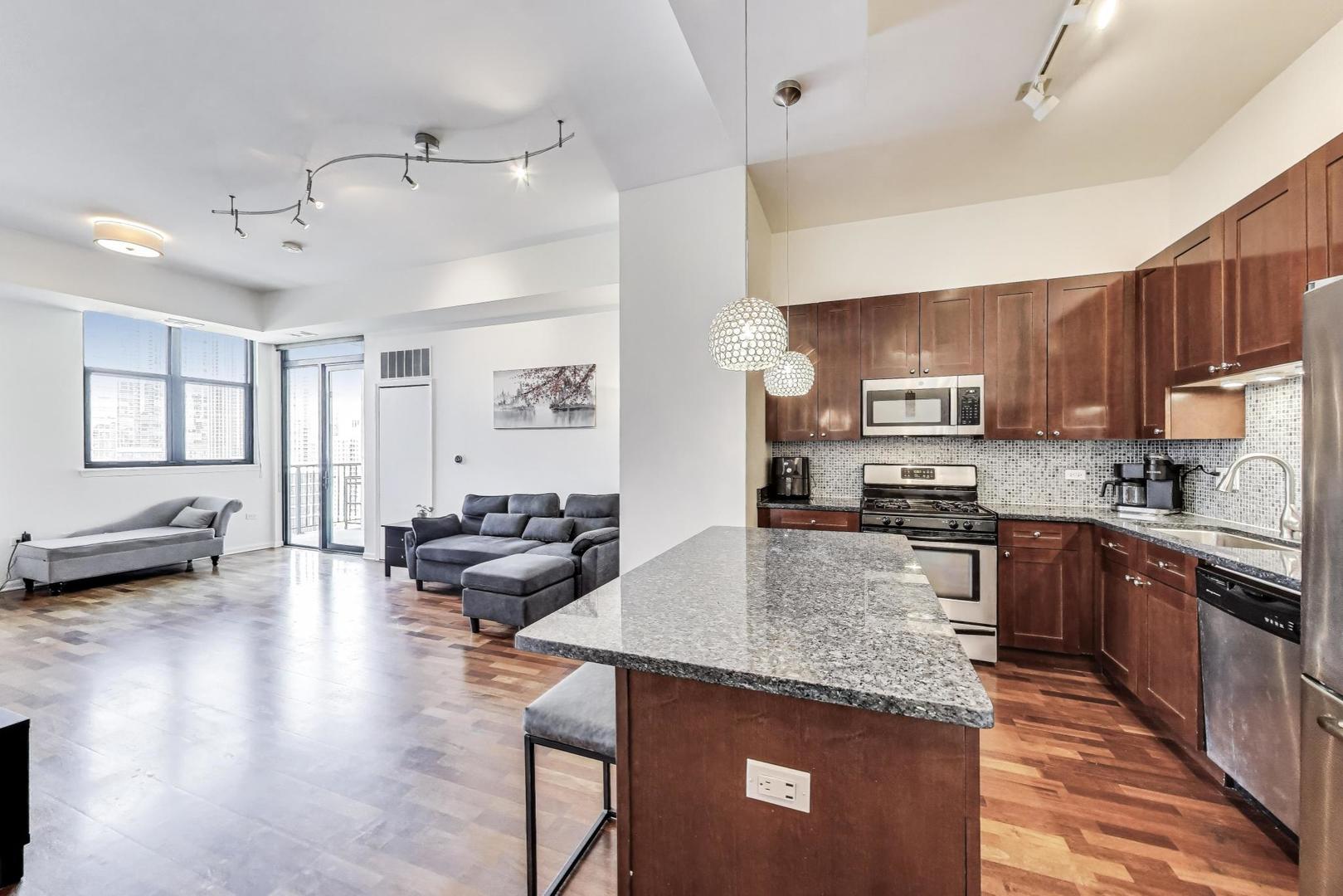 1464 South Michigan Avenue, Unit 1609 Chicago, IL 60605 - Photo 15 of 45 a kitchen with stainless steel appliances granite countertop a sink dishwasher stove top oven and cabinets with wooden floor