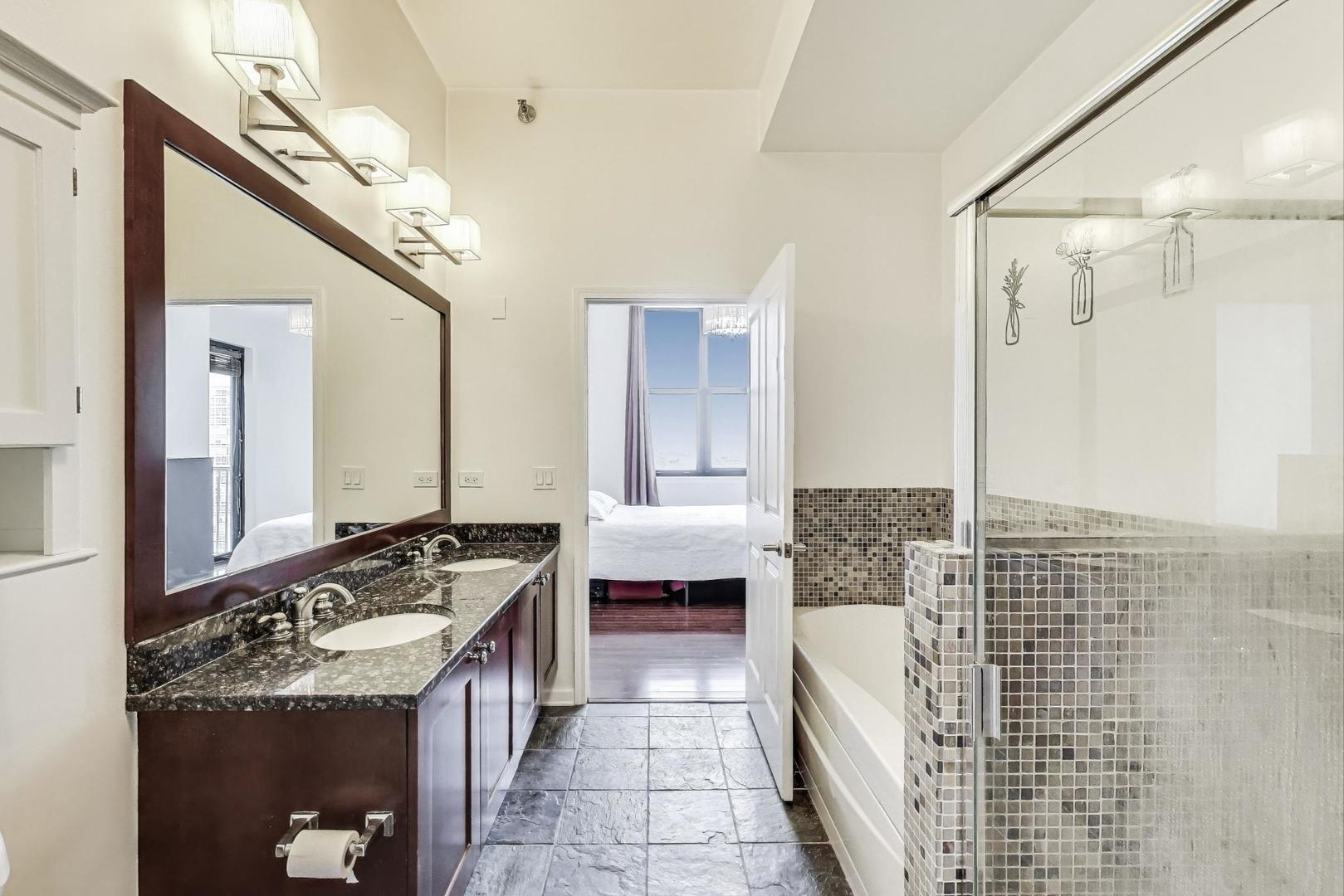 1464 South Michigan Avenue, Unit 1609 Chicago, IL 60605 - Photo 24 of 45 a spacious bathroom with a double vanity sink a mirror and a bathtub