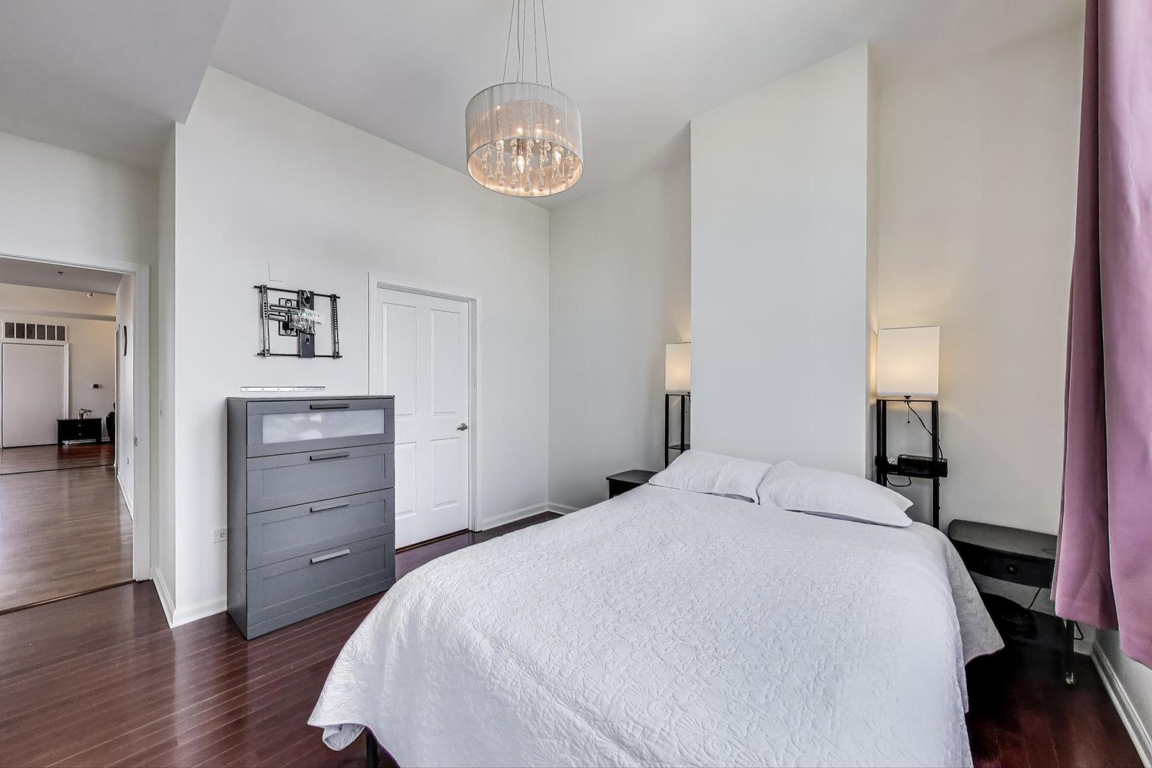 1464 South Michigan Avenue, Unit 1609 Chicago, IL 60605 - Photo 25 of 45 a bedroom with a bed and a chandelier