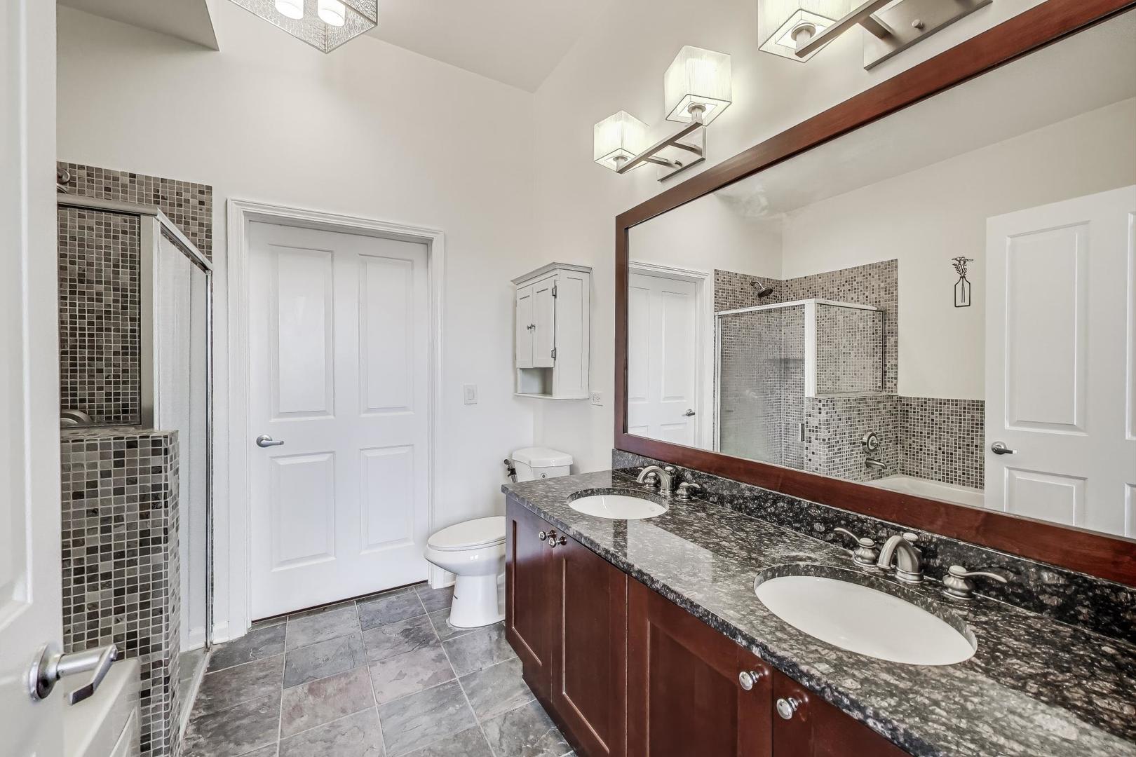 1464 South Michigan Avenue, Unit 1609 Chicago, IL 60605 - Photo 26 of 45 a bathroom with a granite countertop double vanity sink a mirror and a shower