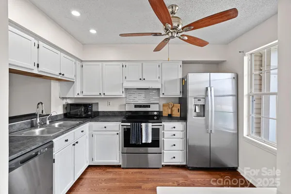 a kitchen with stainless steel appliances a refrigerator sink and cabinets