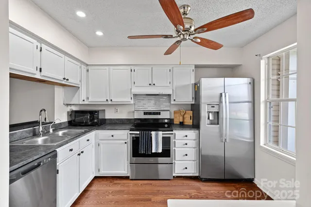 a kitchen with stainless steel appliances a refrigerator sink and cabinets