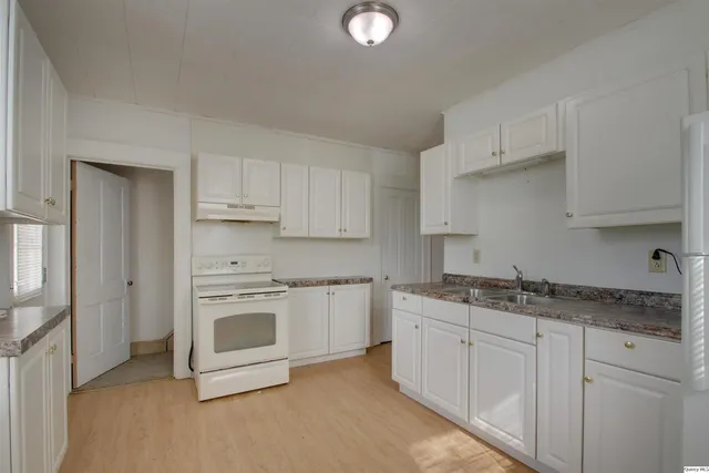 a kitchen with stainless steel appliances granite countertop a sink and cabinets with wooden floor