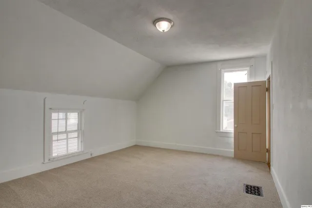 an empty room with windows and closet
