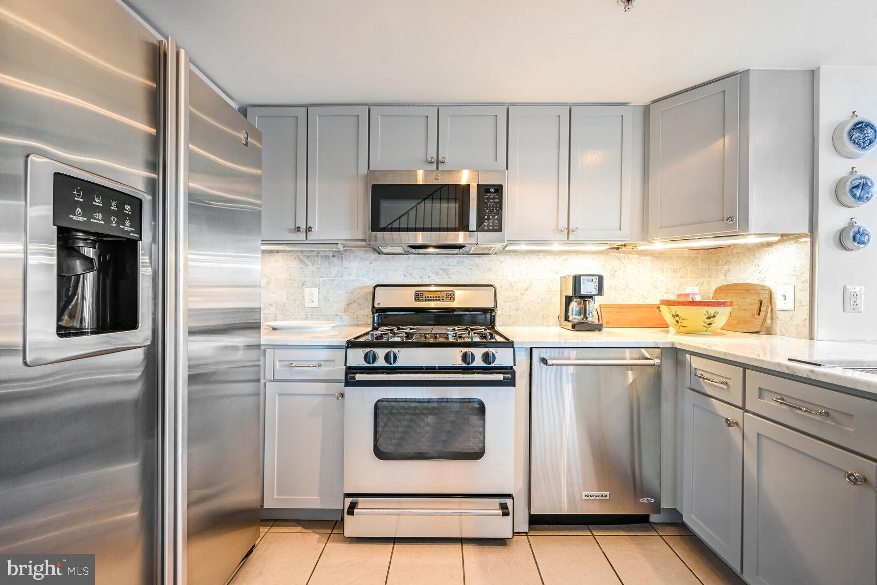 616 E Street Northwest, Unit 1150 Washington, DC 20004 - Photo 9 of 75 a kitchen with white cabinets and stainless steel appliances