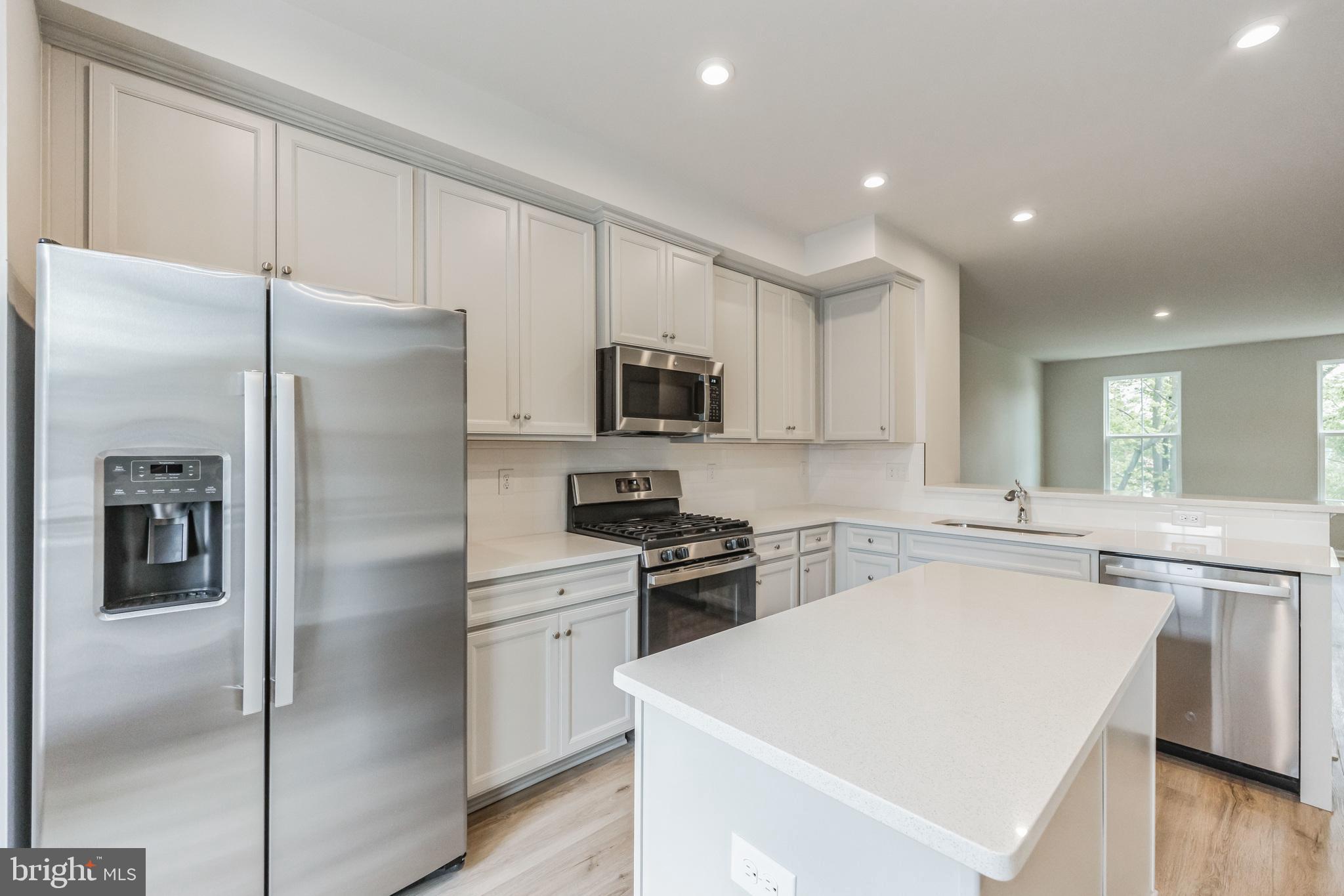 28 Sidney Lane Stratford, NJ 08084 - Photo 8 of 30 a kitchen with a refrigerator a microwave a sink and cabinets