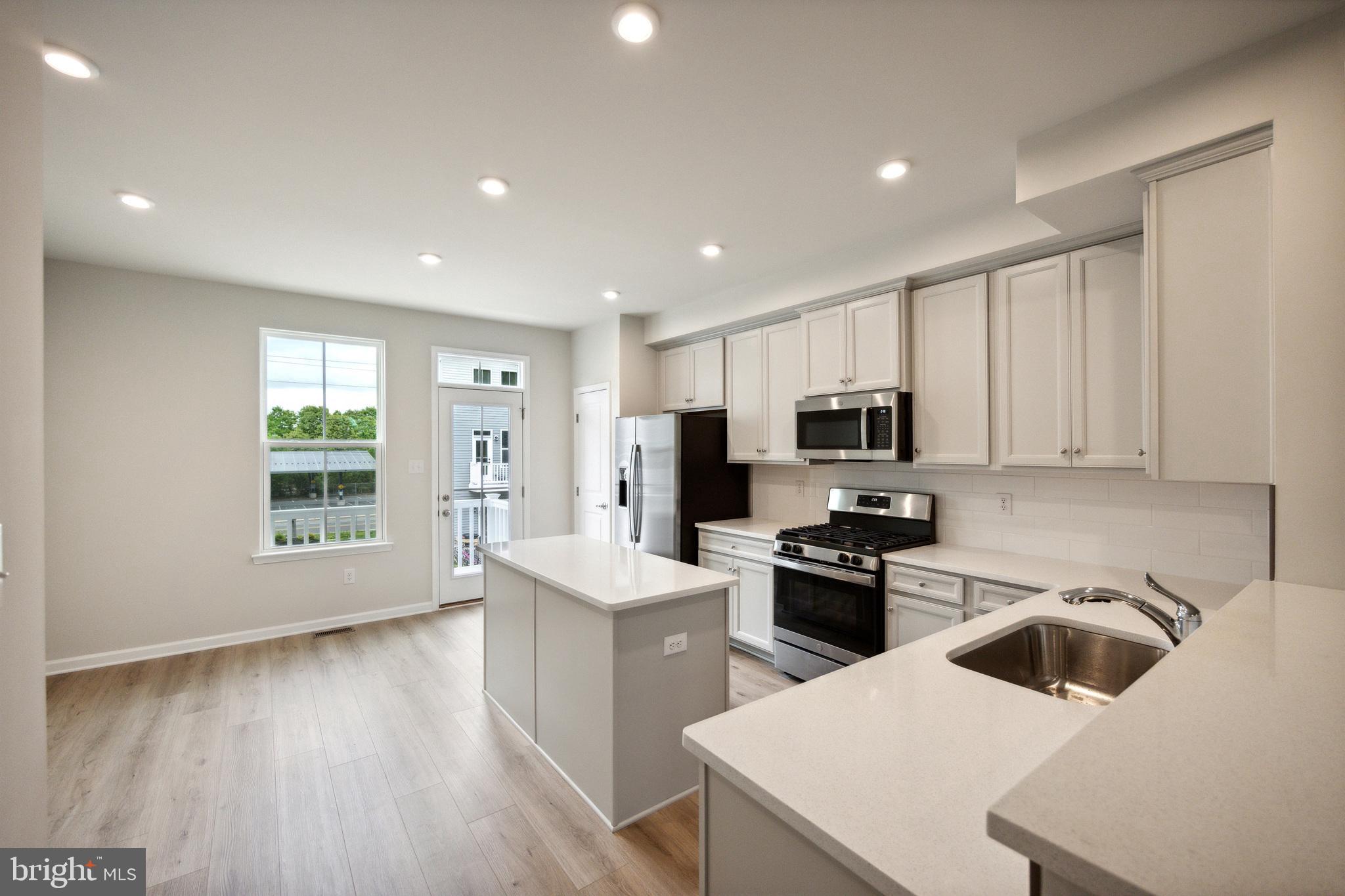 28 Sidney Lane Stratford, NJ 08084 - Photo 9 of 30 a kitchen with a sink a microwave and refrigerator