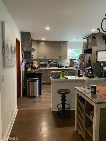 a kitchen with kitchen island granite countertop a sink cabinets and stainless steel appliances