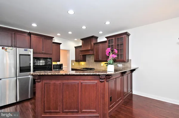 a kitchen with stainless steel appliances granite countertop a refrigerator a stove and a sink