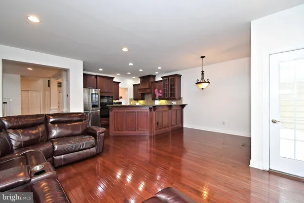 a view of kitchen with kitchen island microwave and wooden floor