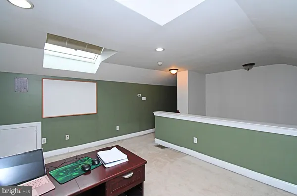 a room with painting on the wall and a window