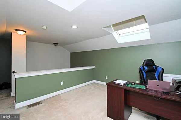 a room with painting on the wall and a potted plant