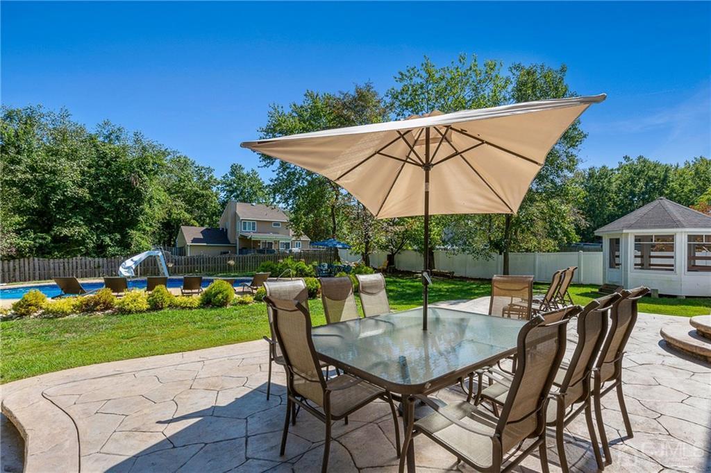 461 Cottrell Road Old Bridge, NJ 08857 - Photo 21 of 21 a patio with a table and chairs under an umbrella