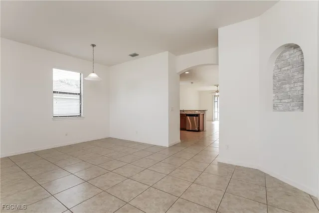 an empty room with windows and fireplace