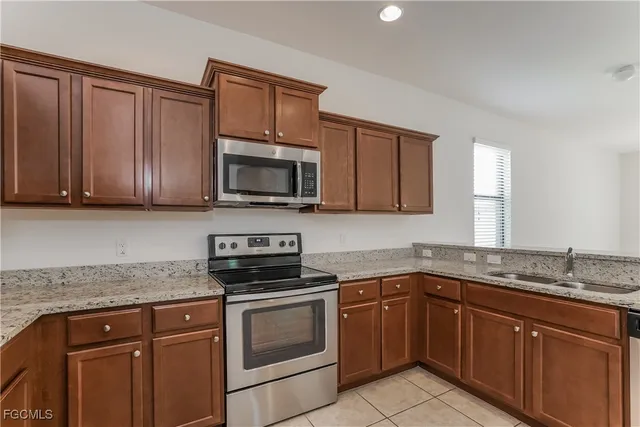 a kitchen with stainless steel appliances granite countertop a sink stove and microwave