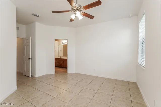 a view of an empty room and chandelier fan