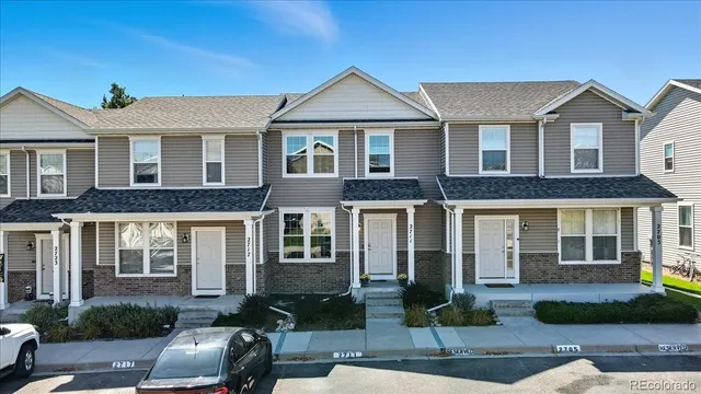 a front view of a house with yard and parking