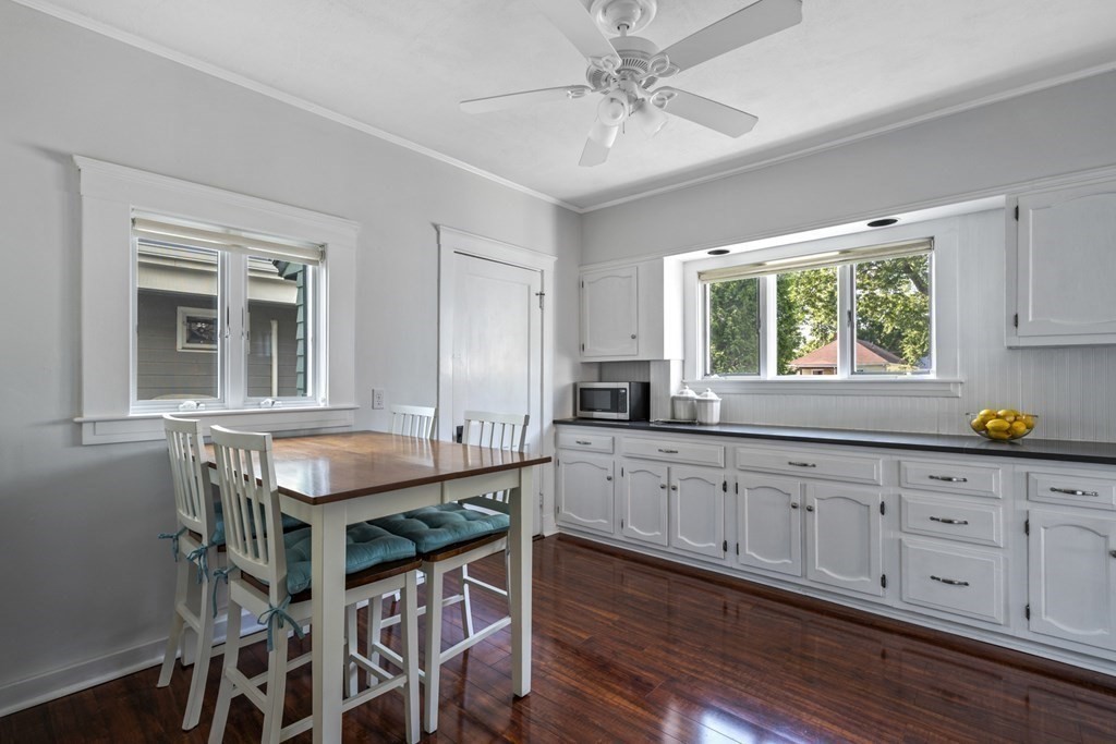 64 Farragut Road Swampscott, MA 01907 - Photo 12 of 35 a kitchen with granite countertop a table chairs wooden floors and white cabinets