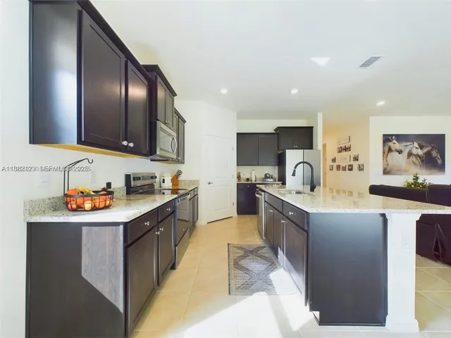 a large kitchen with stainless steel appliances lots of counter top space