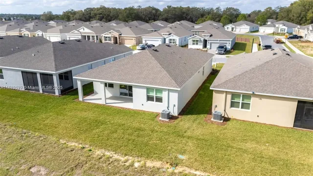 an aerial view of residential houses with yard
