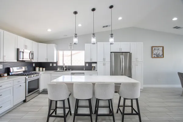 a large kitchen with a table and chairs