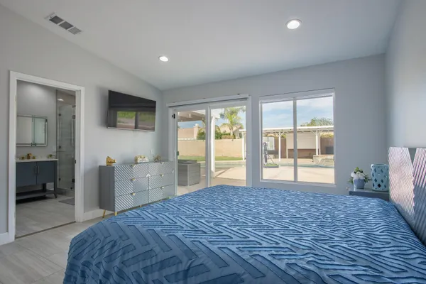 a bedroom with a bed and a flat screen tv