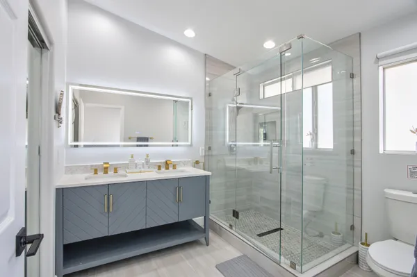 a bathroom with a granite countertop sink mirror and shower