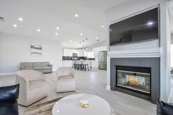 a living room with furniture a flat screen tv and a fireplace