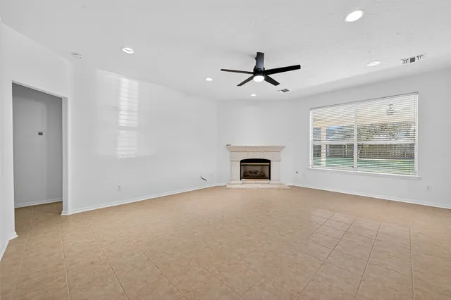a view of empty room with a fireplace and fan