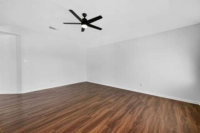 a view of a room with wooden floor and white walls