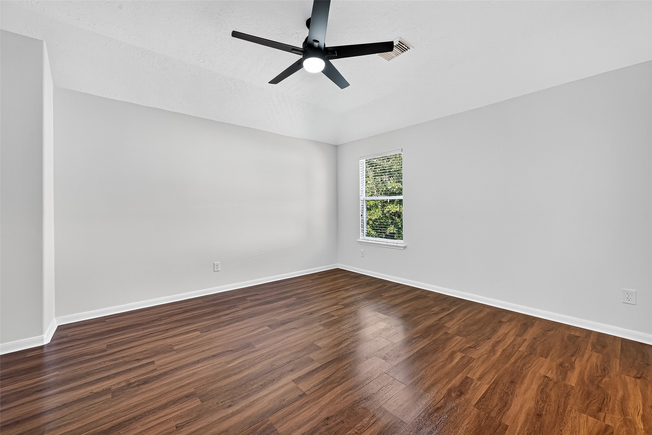 11727 Spring Path Court Tomball, TX 77377 - Photo 34 of 50 an empty room with wooden floor ceiling fan and windows