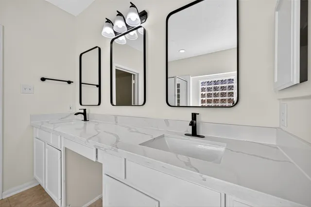 a bathroom with double vanity sink and a mirror