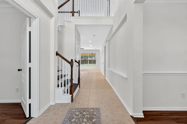 a view of a hallway with wooden floor and entryway