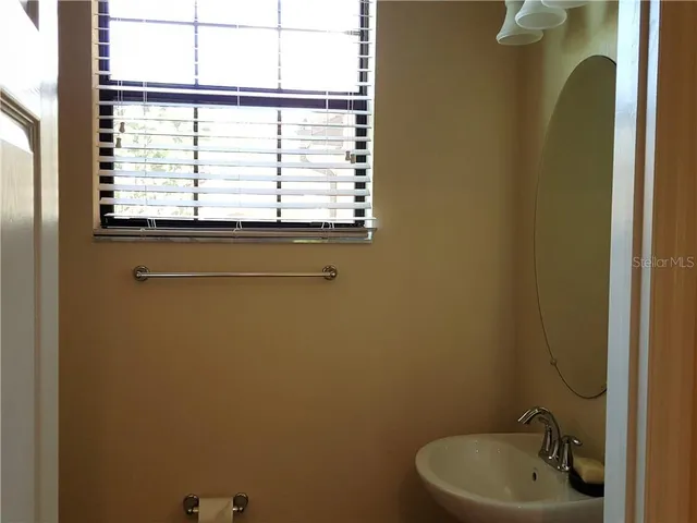 a bathroom with a sink a window and a shower