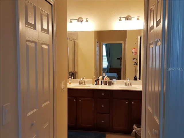 a bathroom with a double vanity sink and a mirror