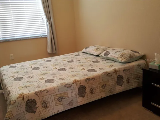 a bedroom with a bed next to a window