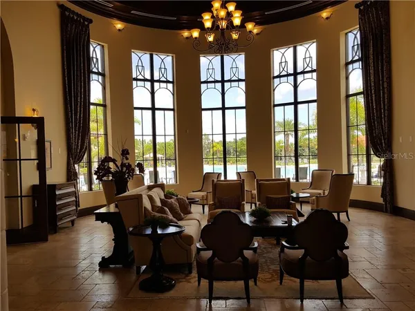 a living room with furniture and floor to ceiling windows
