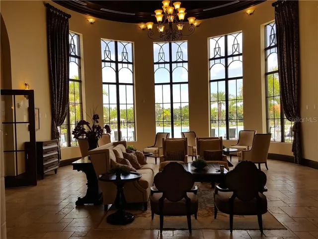 a living room with furniture and floor to ceiling windows
