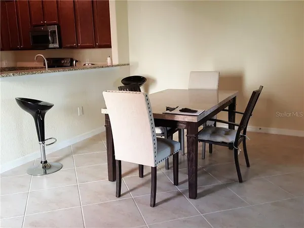 a view of a dining room with furniture and a kitchen view