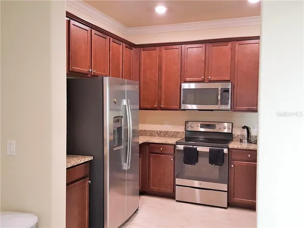 a kitchen with stainless steel appliances granite countertop a refrigerator stove and microwave