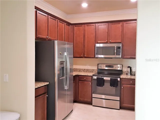 a kitchen with stainless steel appliances granite countertop a refrigerator stove and microwave