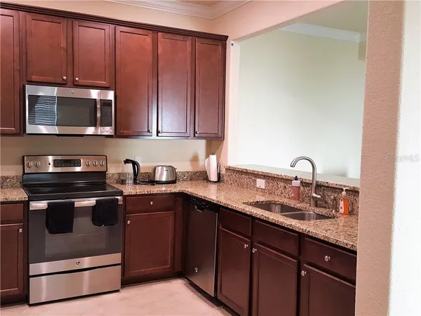 a kitchen with stainless steel appliances granite countertop a sink stove and microwave